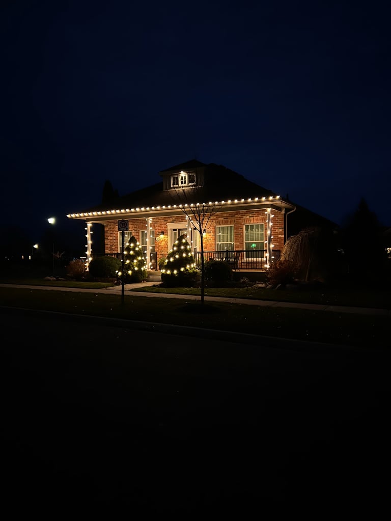 Red brick building decorated with warm white holiday lights at night against dark blue sky